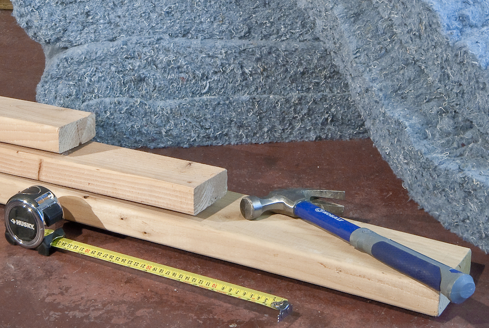 Installing Recycled Blue Jean Denim Insulation In Wall Frame Stock