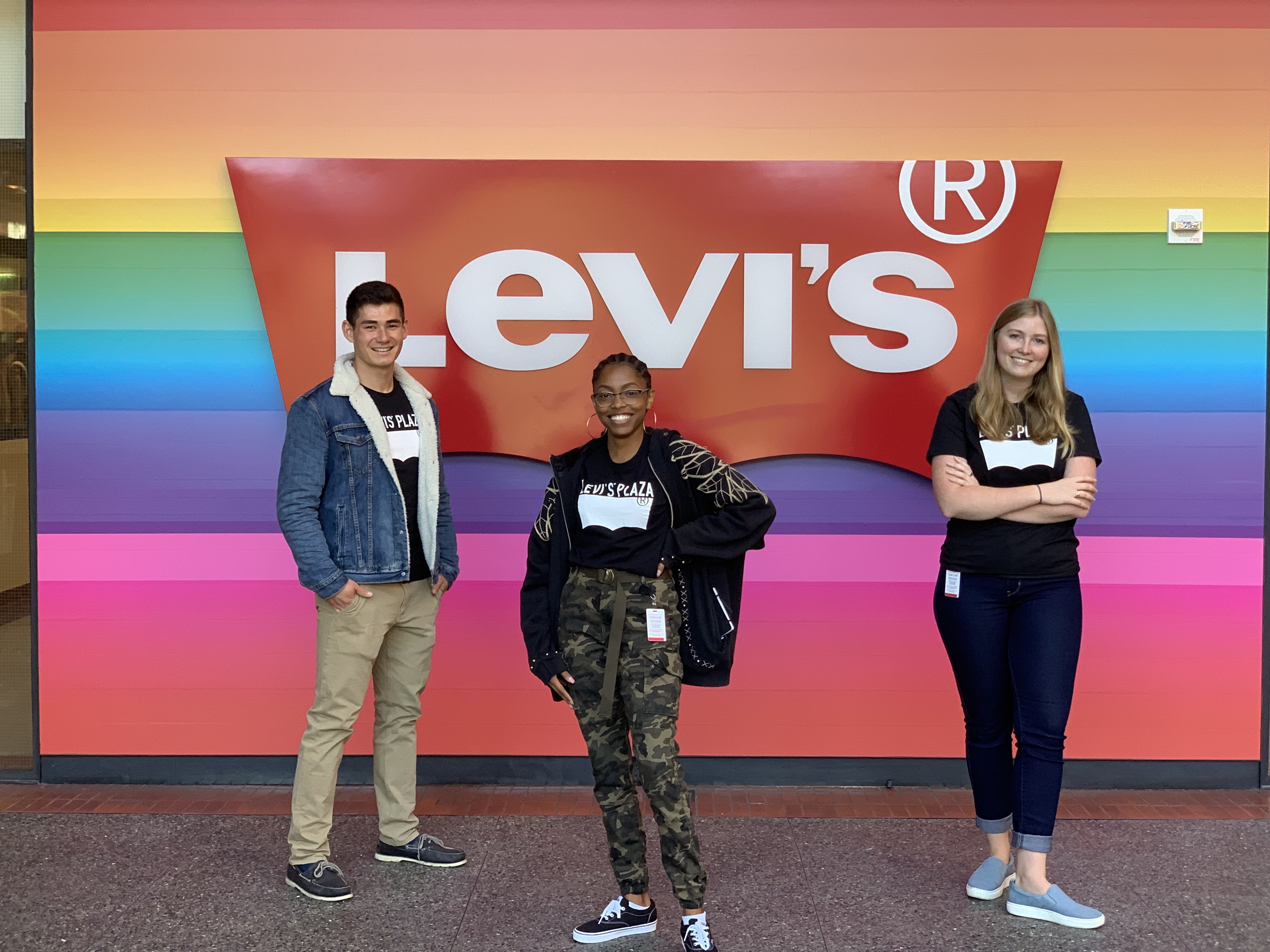 three interns in front of levi's logo on rainbow backdrop