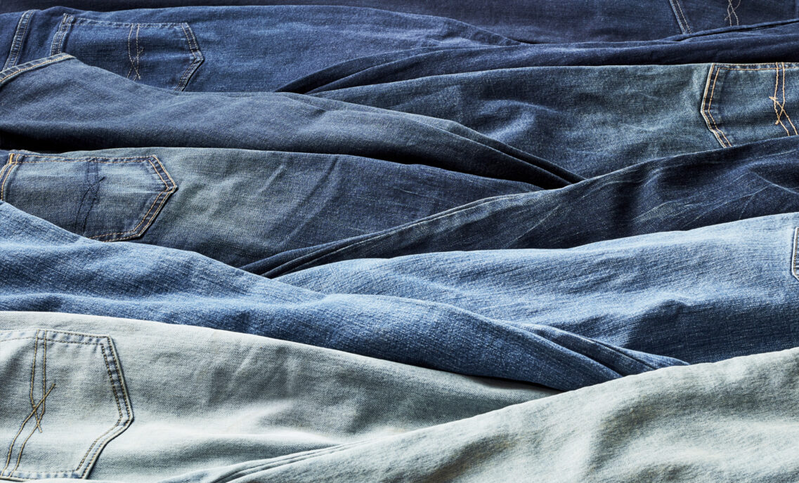 a pile of Levi's® denim jeans of various blue washes lie next to each other