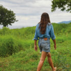 woman walking in grassy field wearing Levi's® denim shorts
