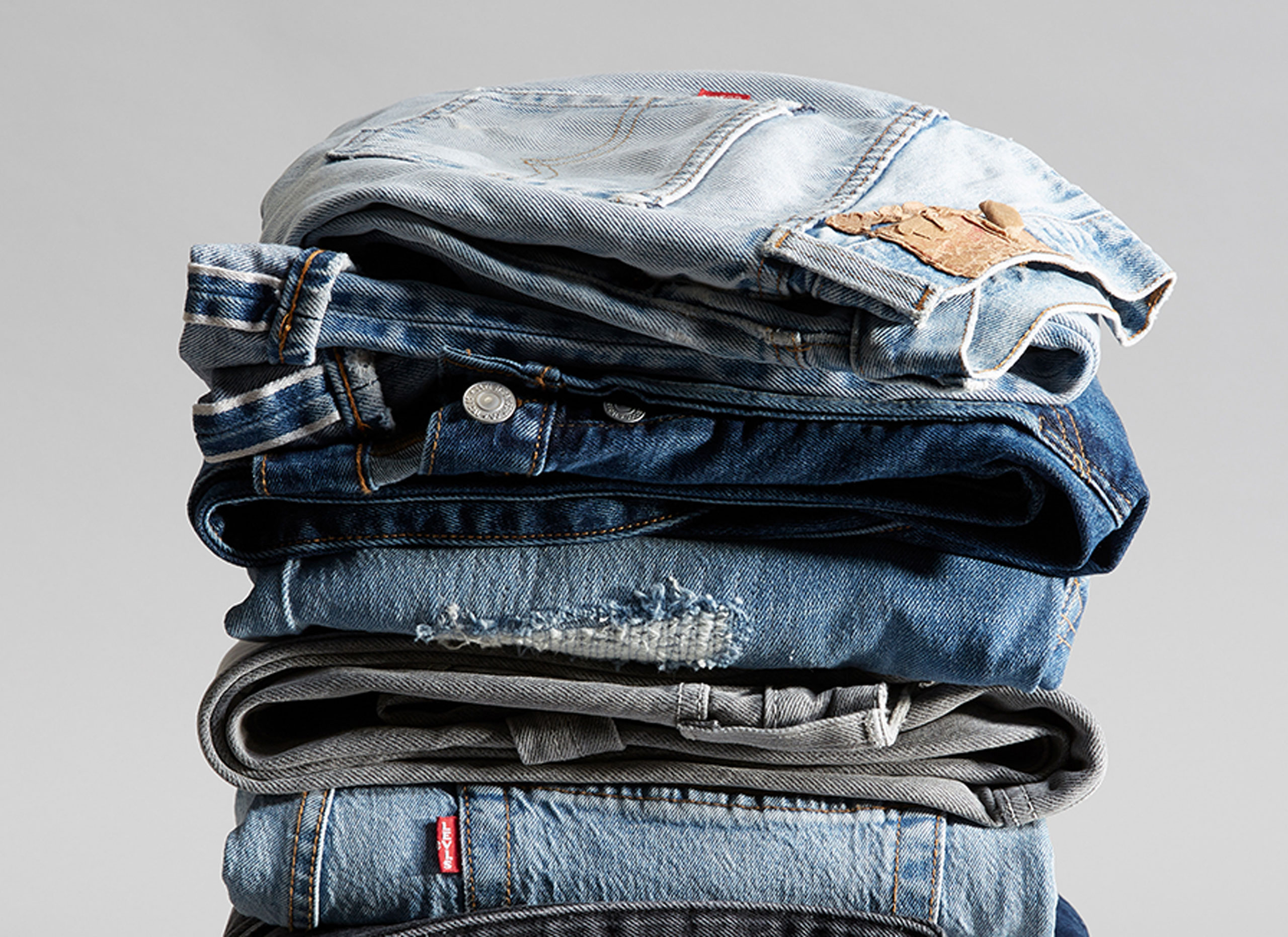 A stack of folded Levi's® jeans in various washes