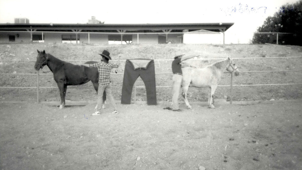 black and white image of two horses attached to a pair of Levi's® overalls to reenact the 2-Horse Pull logo