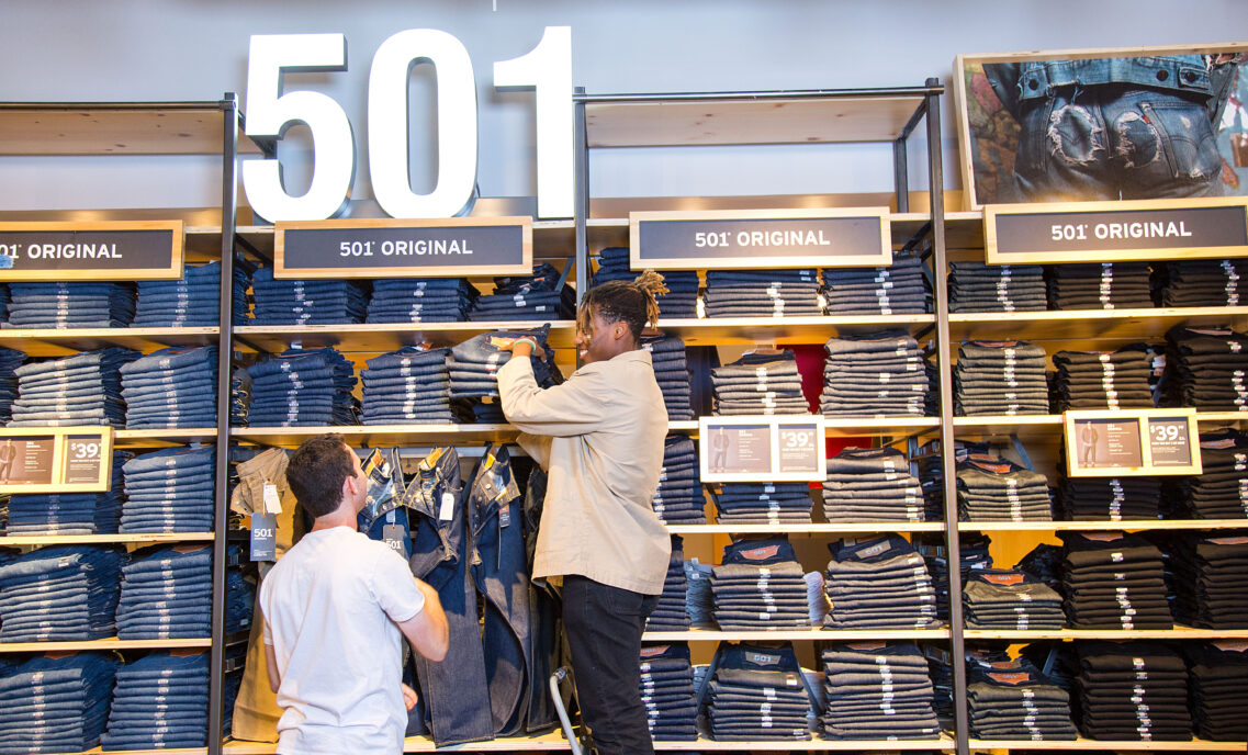 2 retail employees stocking 501® jeans in a Levi's® store