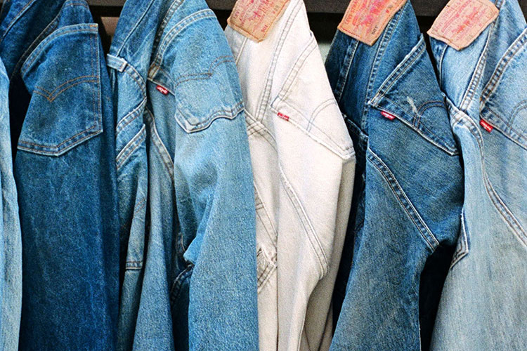 Levi's® jeans in various washes hang from an unseen bar above.