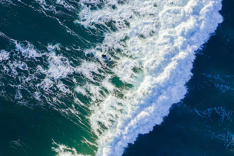 An aerial view of a wave breaking in the ocean