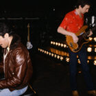 GETTY photo shows Freddie Mercury wearing a brown leather jacket — and what looks like Levi’s® 501® jeans — sitting at the piano while he and John Deacon, also wearing Levi’s® jeans, rehearsed at the Budokan.