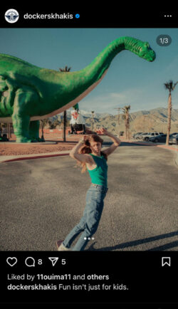 A screenshot of a Dockers® Instagram post. A person rides a skateboard in blue jeans and a green tank top. There is a large green dinosaur in the background. The caption reads "Fun isn't just for kids.​ Featuring our newest styles for Dockers Women, discover the story of a solo trip in Sierra Palm shot by @sebzanella with @sierra_prescott"
