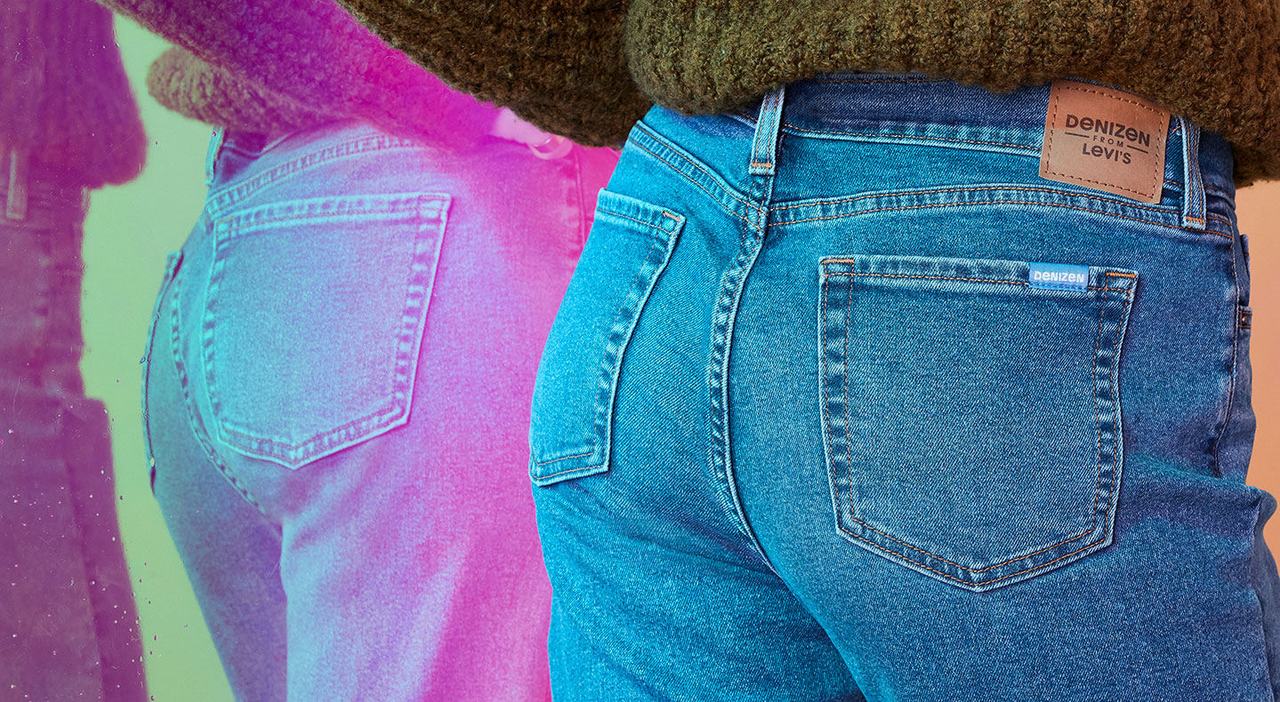 A close up of the back of someone's Denizen From Levi's® jeans. You can barely see a green sweater tucked into the top of the jeans and you can see the reflection to the left with a slightly pink tinge. Photo by Julia Johnson.