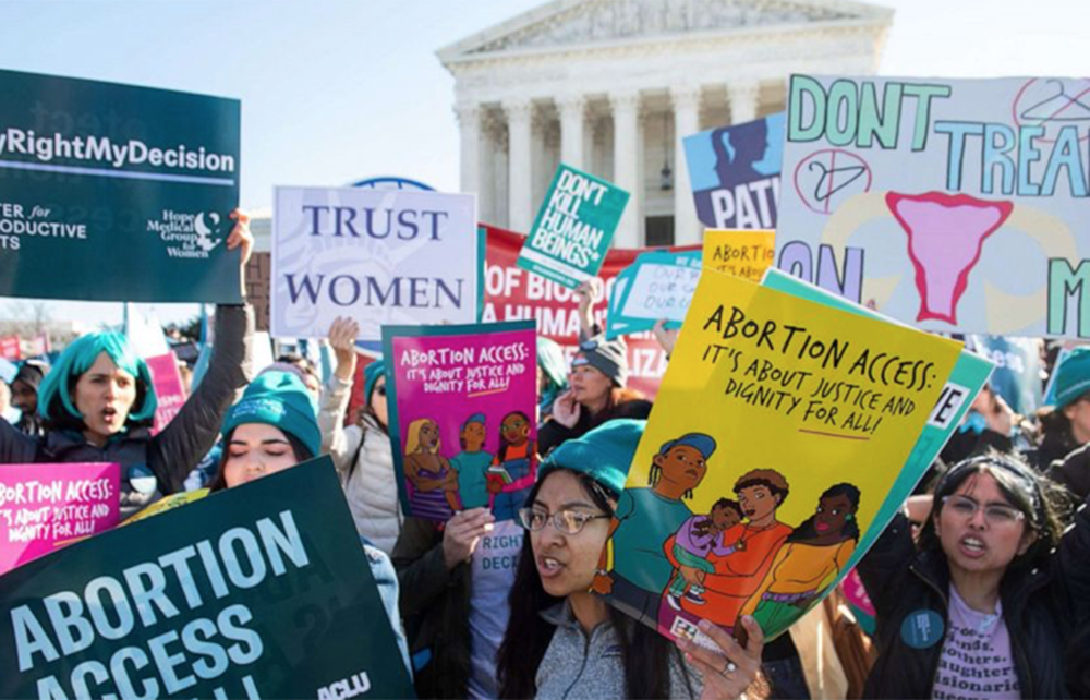 People gather with signs at a reproductive rights protest
