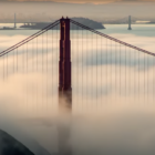 the top of the golden gate bridge peeks out through clouds