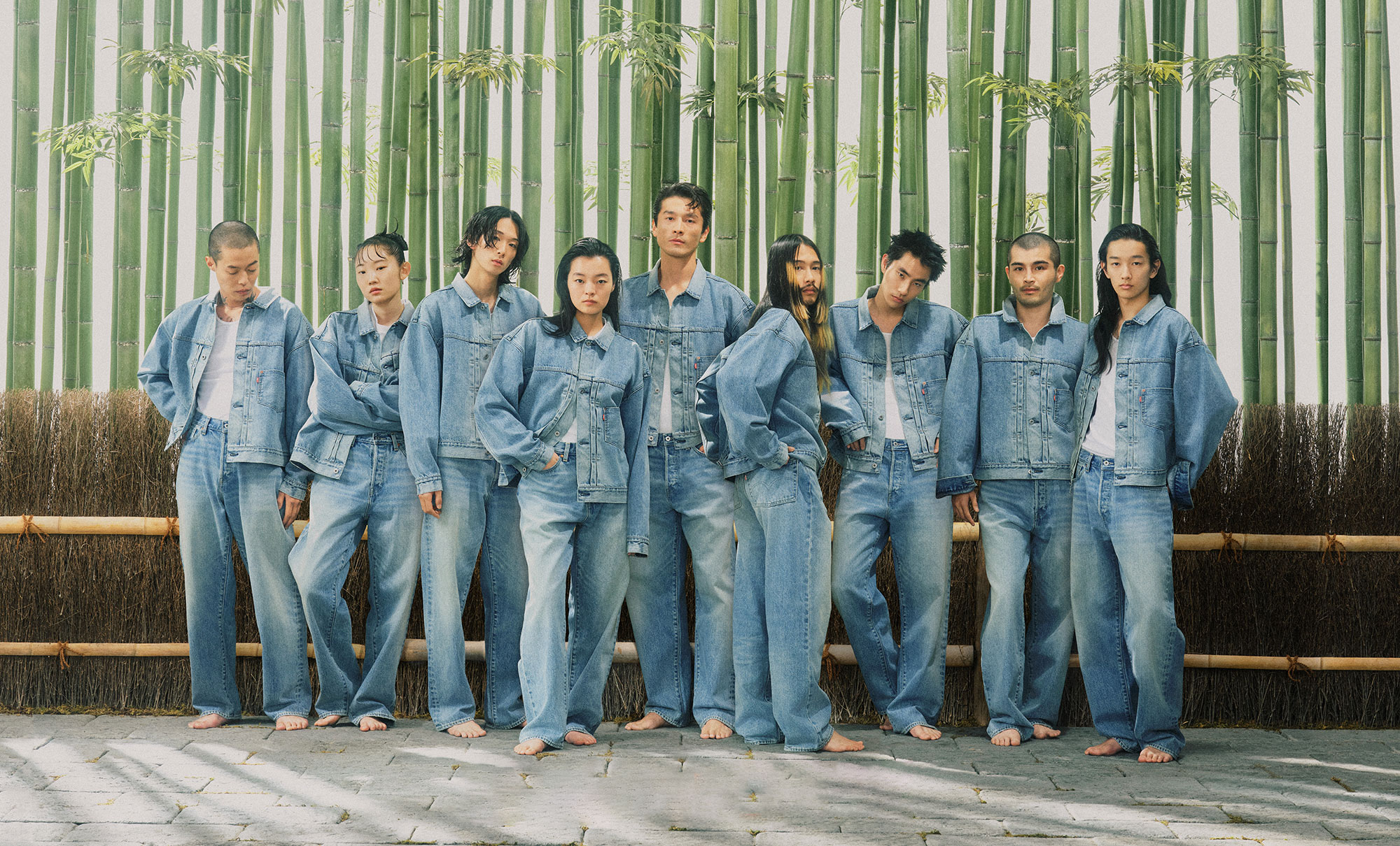 Nine individuals stand against a bamboo background and wear head-to-toe denim looks from the new Levi's® x BEAMS collection.