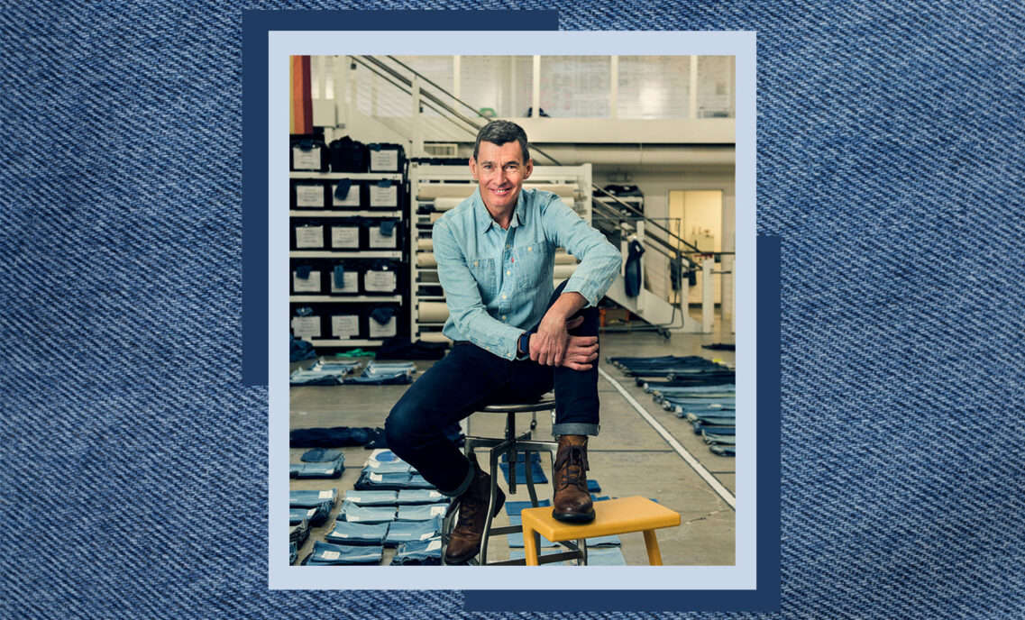 LS&Co. CEO Chip Bergh poses on a stool. The photo is overlayed on a denim texture background.