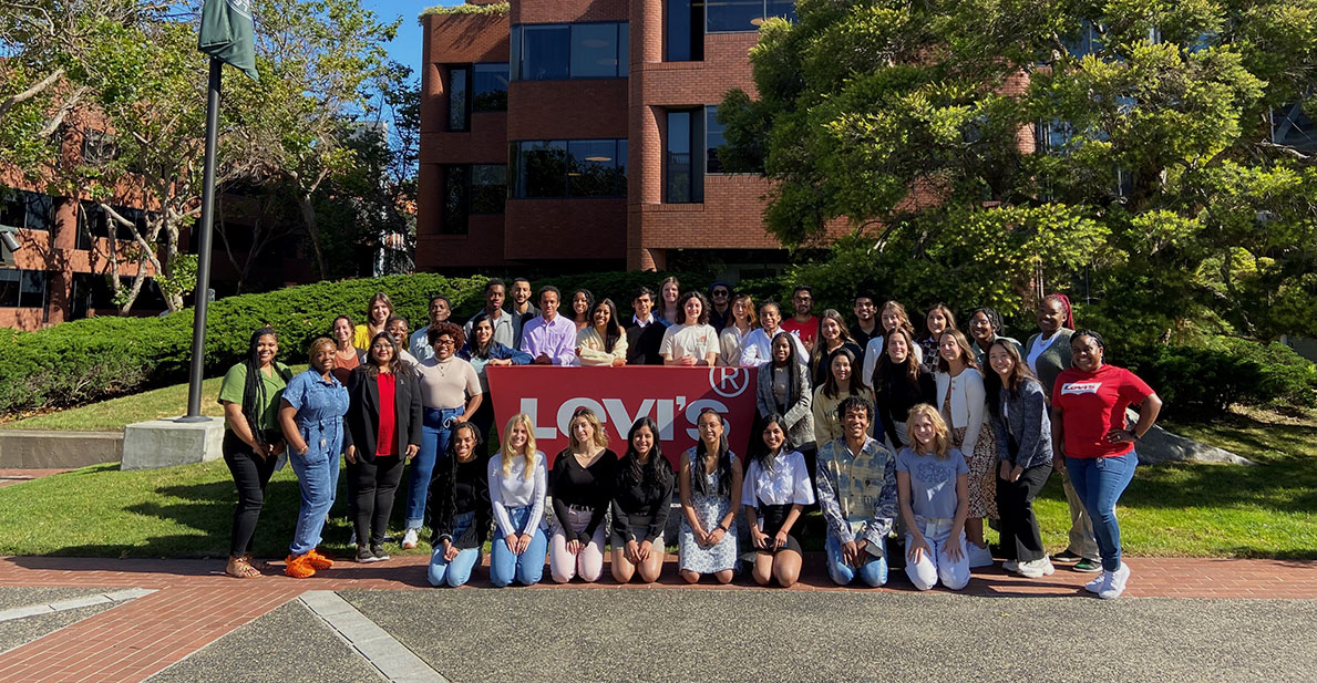 The LS&Co. 2022 interns pose in front of the San Francisco Levi's® office by a large red Levi's® logo