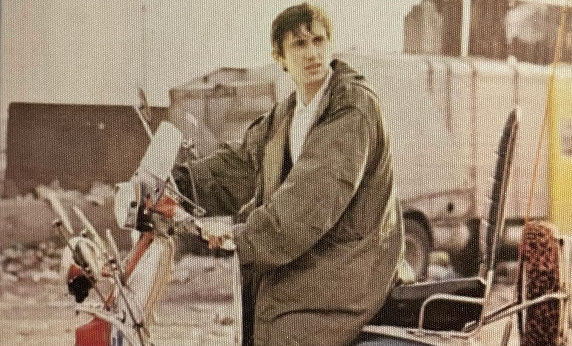 Protagonist character Jimmy Cooper sits on a red scooter with his hands on the handlebar in the 1979 film “Quadrophenia,” wearing a military fishtail parka and looking off towards the right.