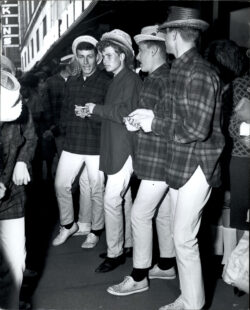 a black and white image of the Beach Boys wearing button up long sleeve plaid shirts, straw fedoras and white pants.