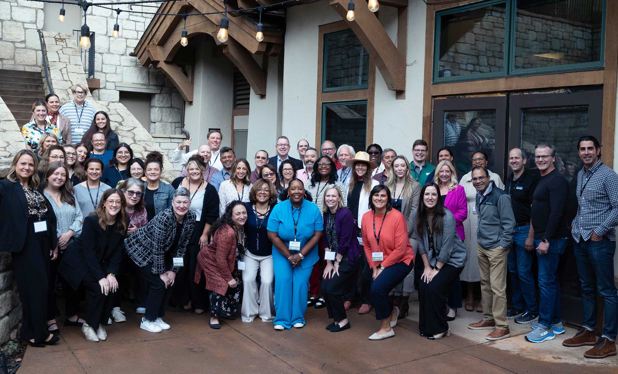Employees from Levi Strauss & Co.'s Red Tab Foundation, the Epic Promise Fund at Vail Resorts and leaders from other companies including Home Depot, HCA Healthcare, Chick-fil-a, Giving Kitchen adn Walmart smile for a group photo in front of a Vail Resorts building facade.