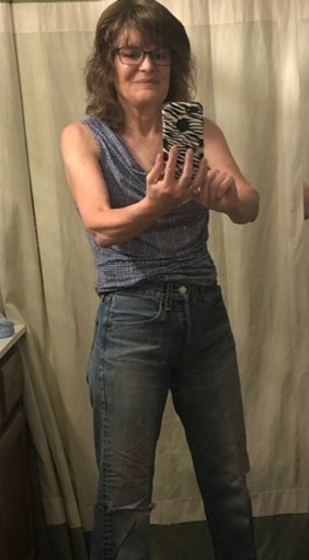 A woman wearing 501 jeans taking a photo of herself in a changing room