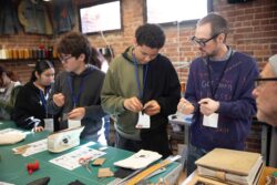 LS&Co. VP and Head of Design Innovation Paul Dillinger stands next to a local San Francisco high school student sewing a patch of denim as part of a Levi's® Wear Longer Project workshop at the LS&Co. Eureka Innovation Lab