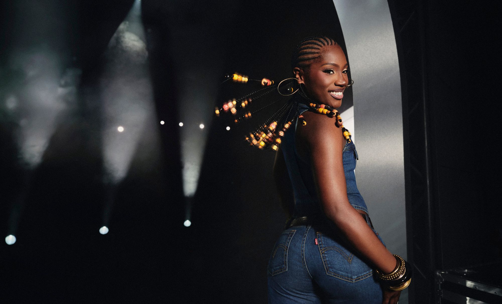 Doechii looking over her shoulder while wearing Levi's jeans