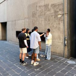 Five Levi Strauss & Co. employees stand on a cobblestone street in Australia wearing casual summer Levi's® outfits