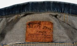 A close up photo of the inside collar patch of a Levi's® denim jacket, featuring handwritten text reading "Betty Jane Moore Fairfield Suisun Army Air Base"