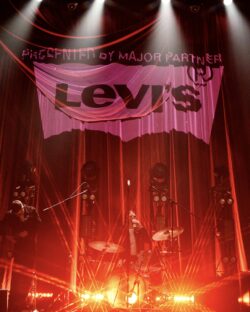 A curtain on stage featuring a projection of the Levi's® batwing logo 