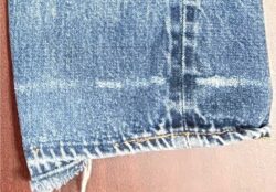 The bottom hem of a pair of Levi's® 501® jeans, featuring a faded white cuff line slightly above the hem.