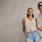 Two models wearing Levi's® summer product lean against a grey backdrop