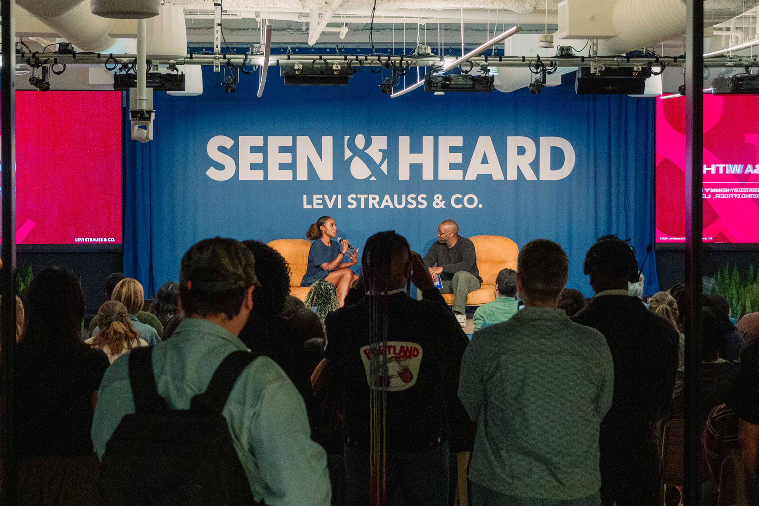 LS&Co. employees watch Issa Rae and LS&Co. Chief Marketing Officer Kenny Mitchell present on stage in front of a sign reading 