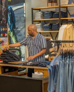 A Levi's® retail employee stands behind the counter of a Levi's® store folding jeans