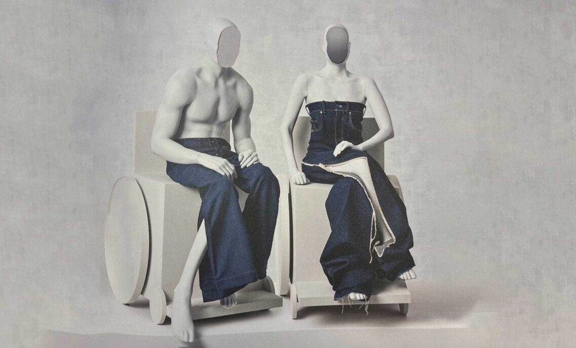 Two pale grey mannequins in wheelchairs wear denim Levi's outfits against a grey backdrop as part of The Met’s “Costume Art” exhibit