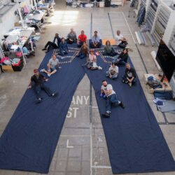 An aerial photo of the crew at the Levi Strauss & Co. Eureka Innovation Lab sitting on top of a supersized pair of Levi's® 501® jeans they created for the 2026 State Fair of Texas
