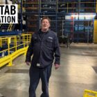 LS&Co. warehouse technician stands inside a warehouse. A Red Tab Foundation logo sits in the top left corner.