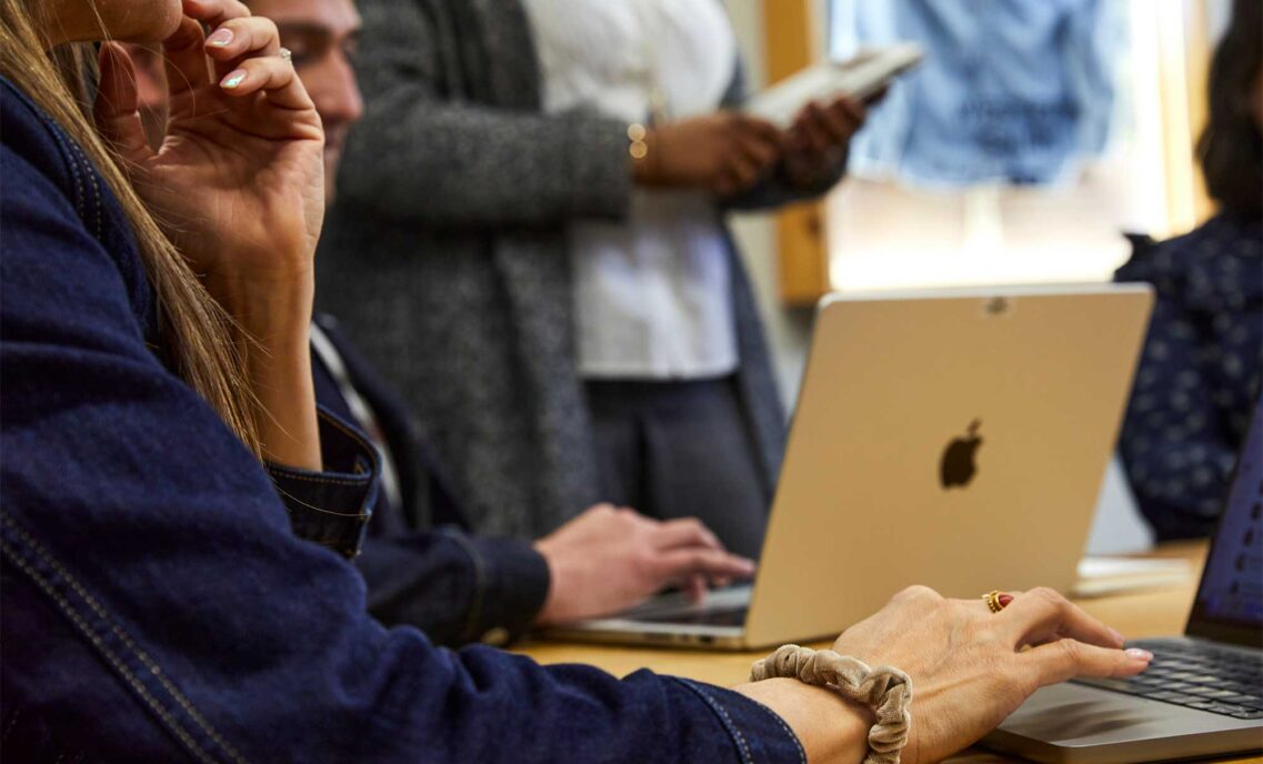 hands typing on a laptop keyboard