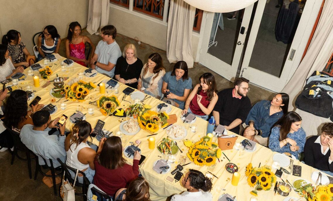 an aerial photo of a large group of people sitting around a dinner table