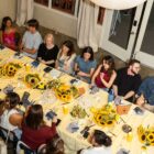 an aerial photo of a large group of people sitting around a dinner table